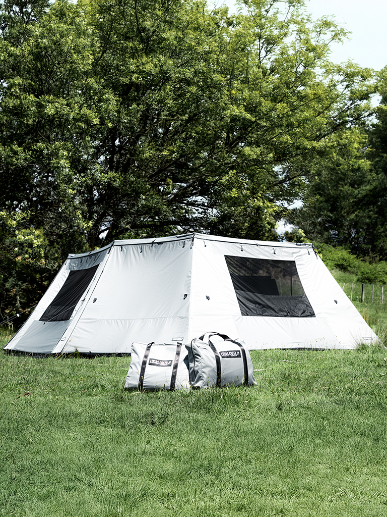 Lucas Creek 180 Fantail free standing car awning with full wall kit installed showing the handy carry bags in front of